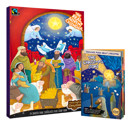 The Real Advent Calendar dark chocolate box with its accompanying Christmas story booklet, on a transparent background.